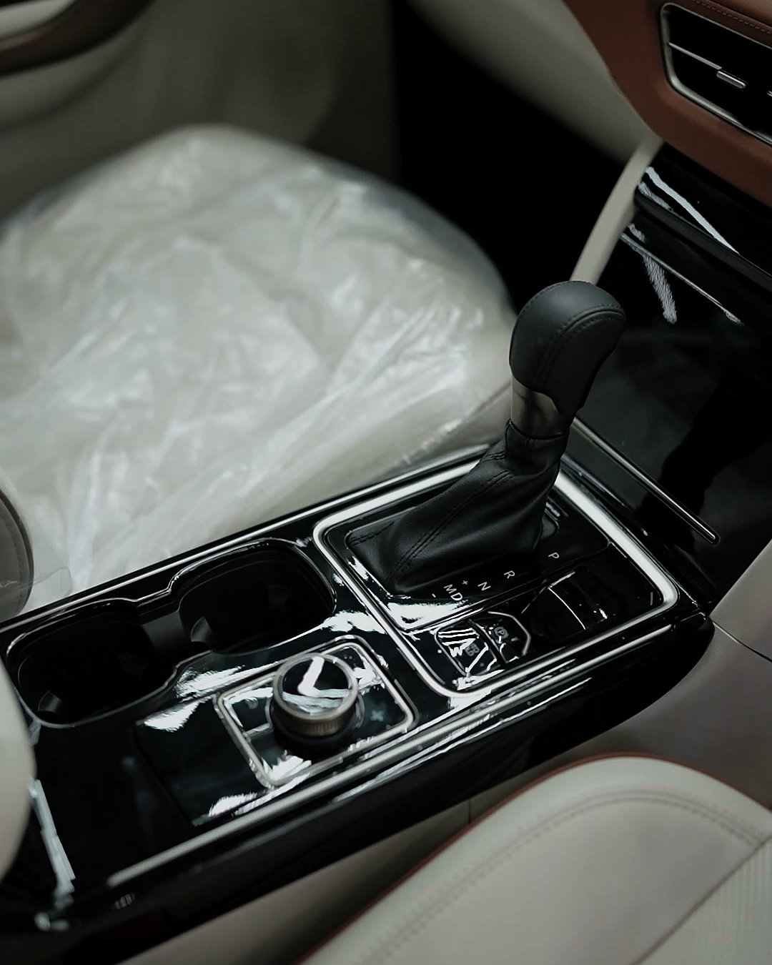 Clear film on a centre console, with the front seat still in its plastic cover.